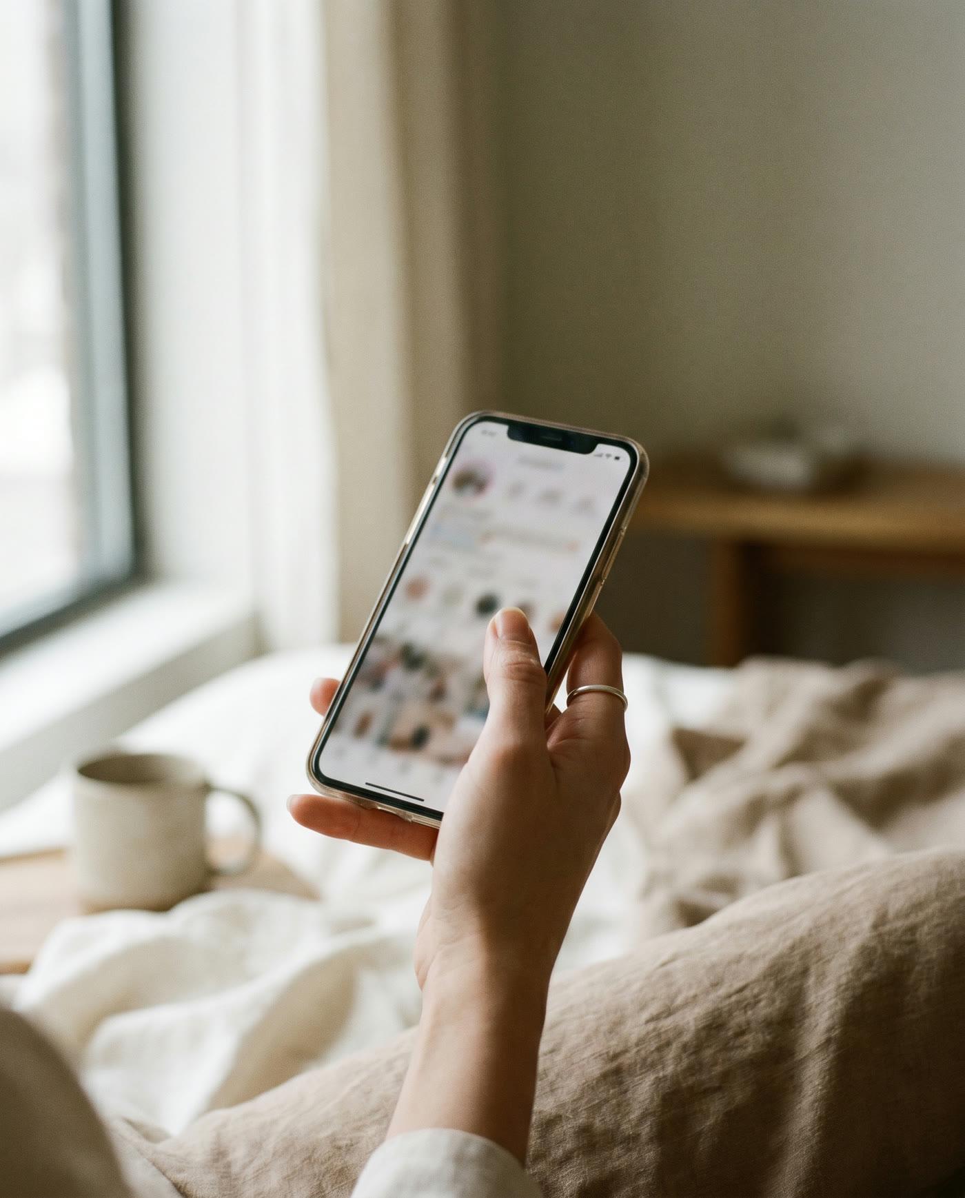 a hand holding a phone, scrolling instagram